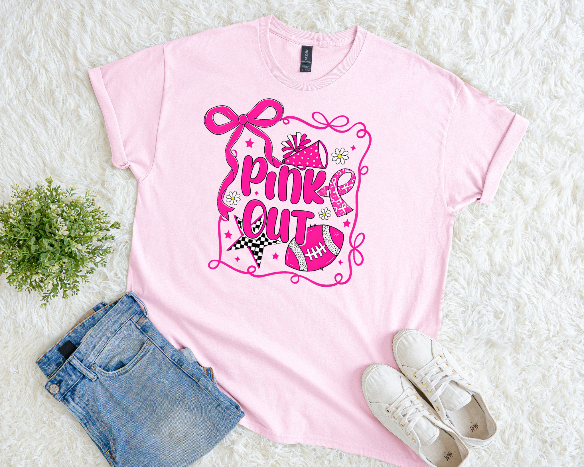 Light pink breast cancer awareness t-shirt with a cheer megaphone, football, stars, bow, and pink ribbon design and the phrase “Pink Out.”