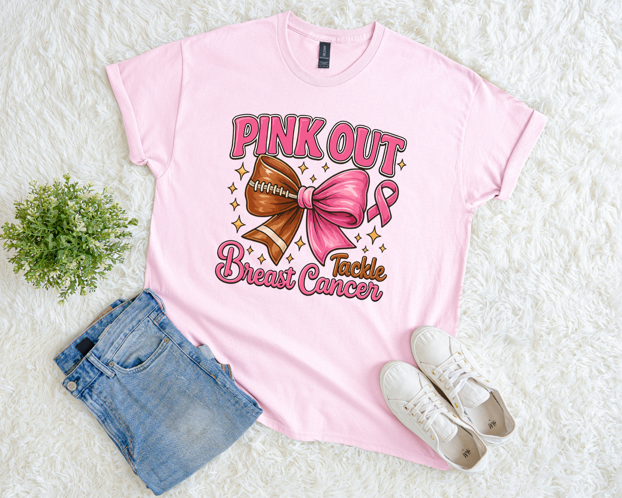 Light pink breast cancer awareness t-shirt with a football and pink bow design, pink ribbon details, and the phrase “Pink Out Tackle Breast Cancer.