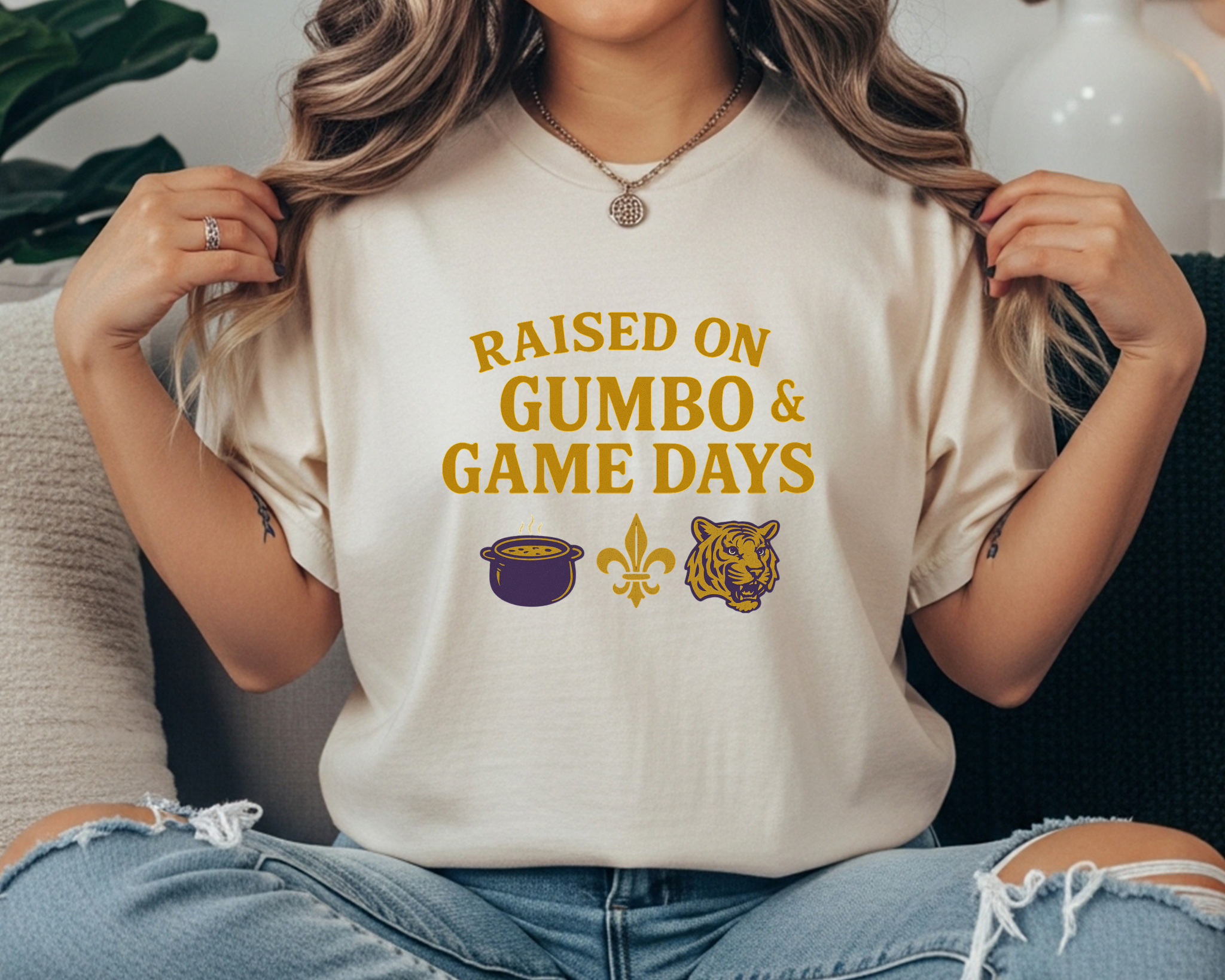 Comfort Colors tee with “Raised on Gumbo & Game Days” text and icons of a gumbo pot, fleur-de-lis, and tiger in gold and purple.