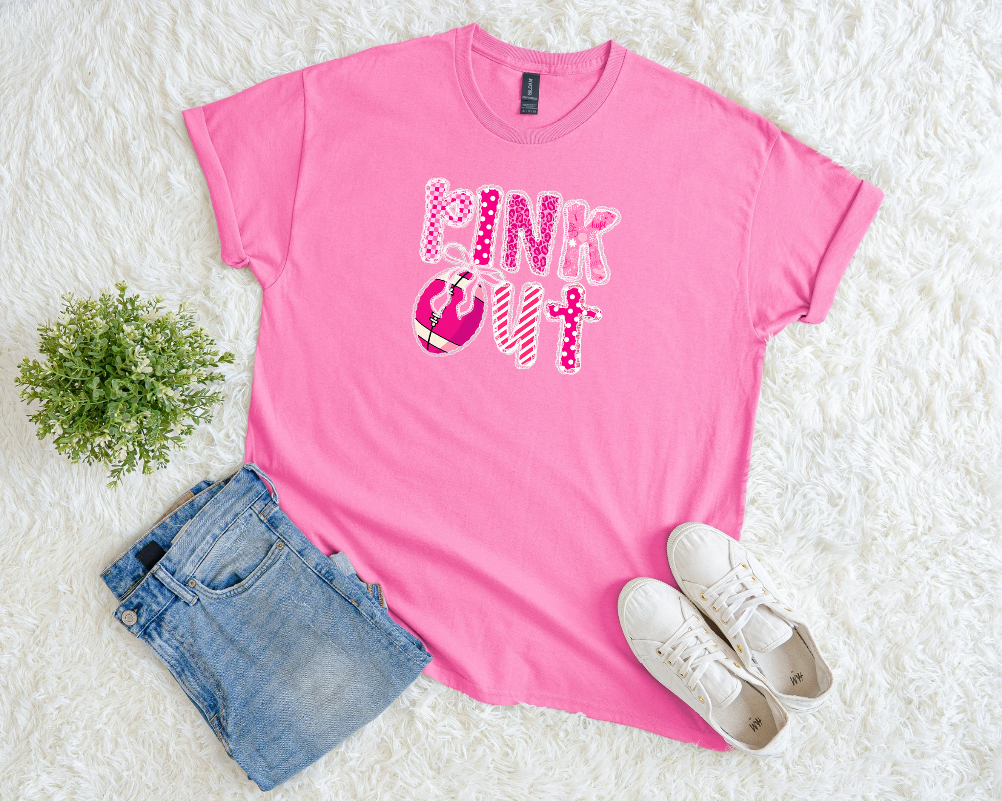 Light pink breast cancer awareness t-shirt with bold patterned “Pink Out” lettering, football graphic, and pink ribbon detail.
