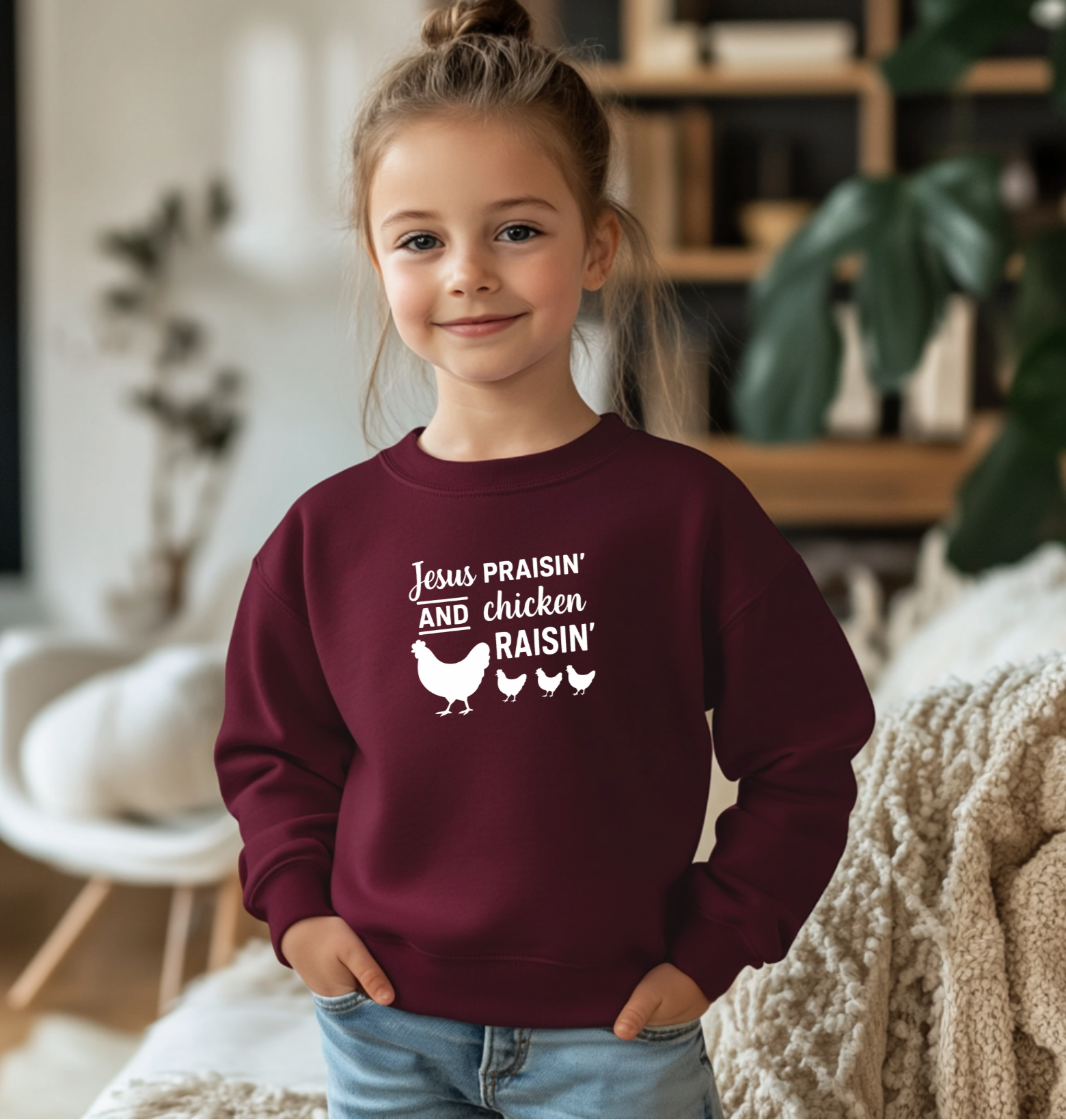 Child wearing a maroon sweatshirt with text and chicken graphics in a home setting