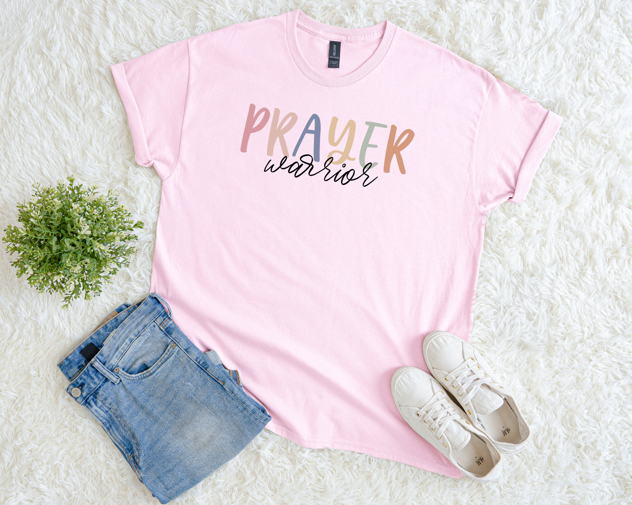 Light pink Christian t-shirt with multicolor text reading “Prayer Warrior.”
