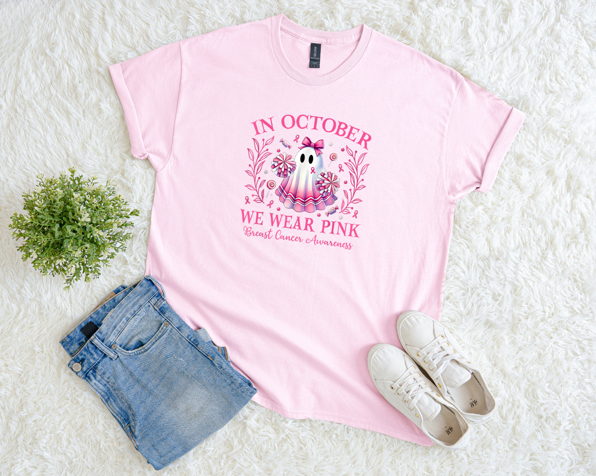 Light pink breast cancer awareness t-shirt with a cute ghost cheerleader design, floral accents, and the phrase “In October We Wear Pink.”