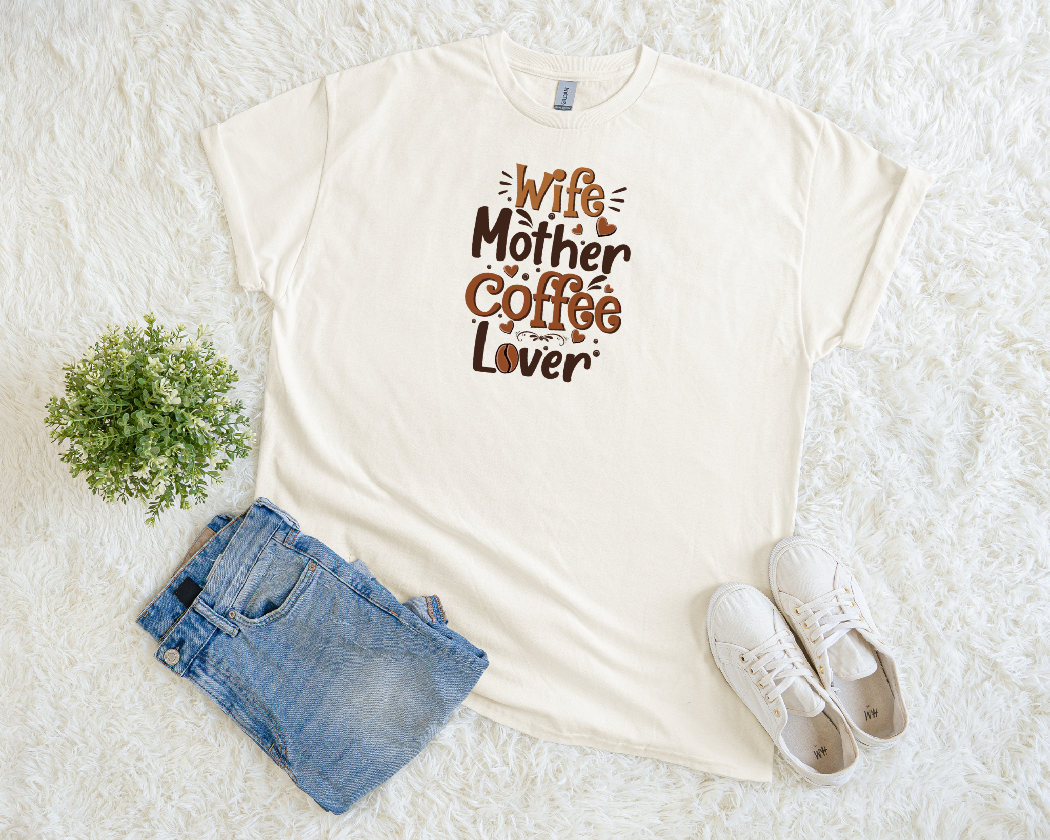 White t-shirt with 'Wife Mother Coffee Lover' text, paired with denim shorts and white sneakers on a light background.