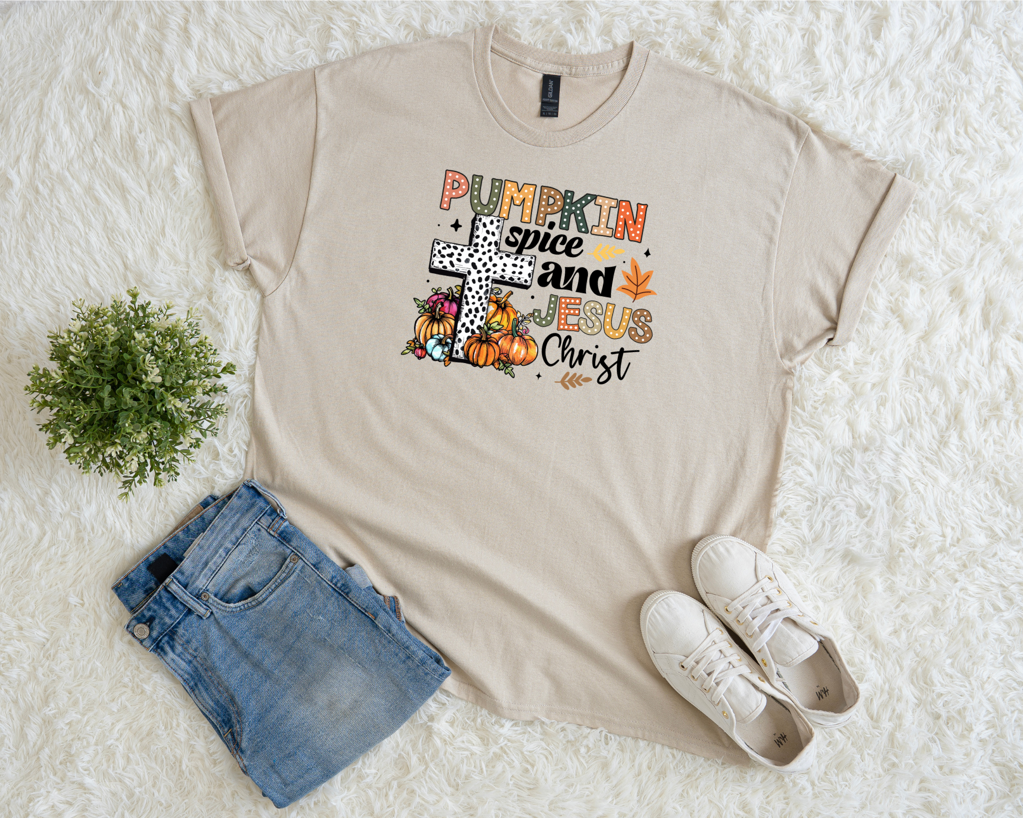 Neutral Christian fall t-shirt with pumpkins, leaves, cross graphic, and the phrase “Pumpkin Spice and Jesus Christ.”