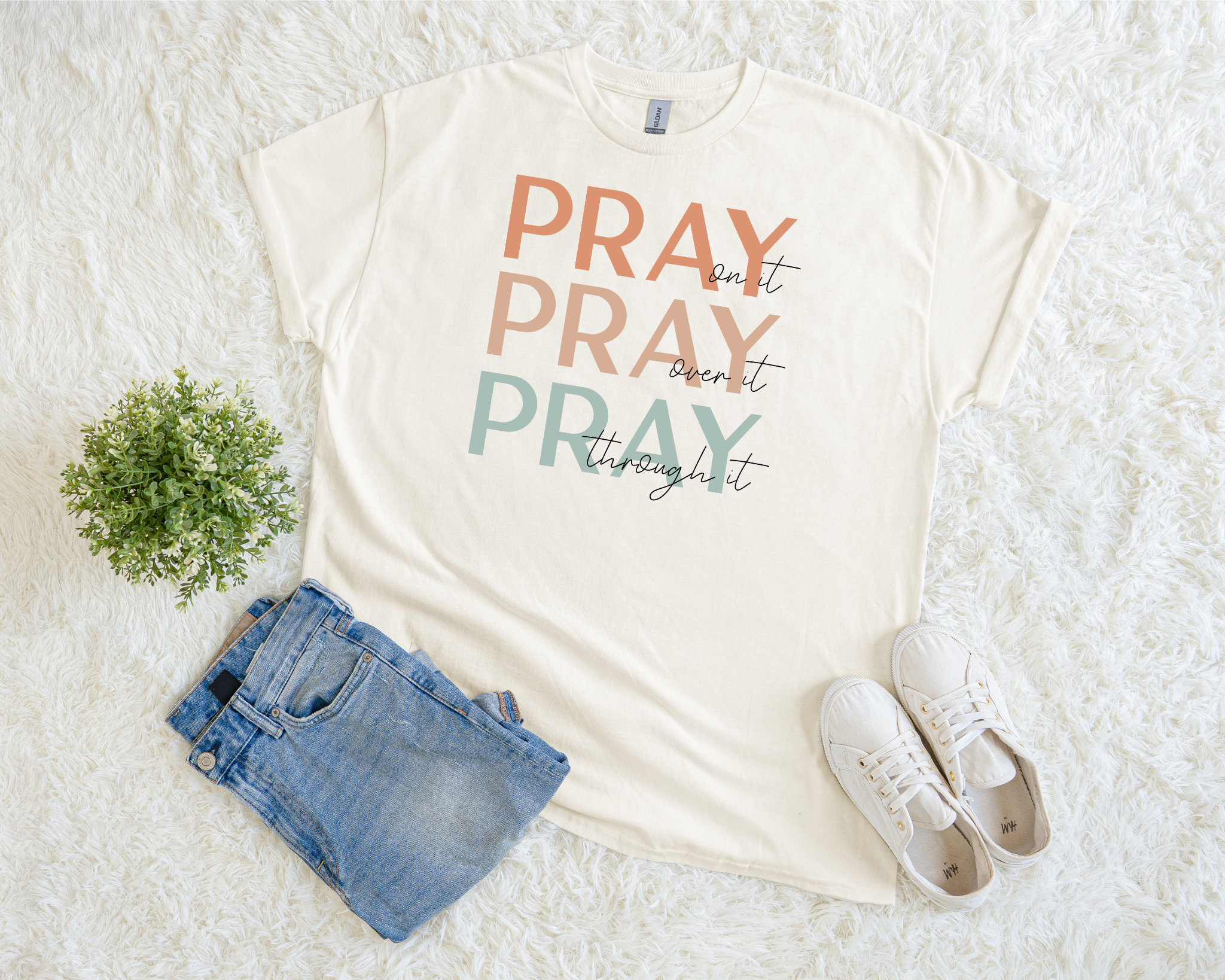 Neutral Christian t-shirt with the phrase “Pray On It, Pray Over It, Pray Through It” in multicolor minimalist lettering.