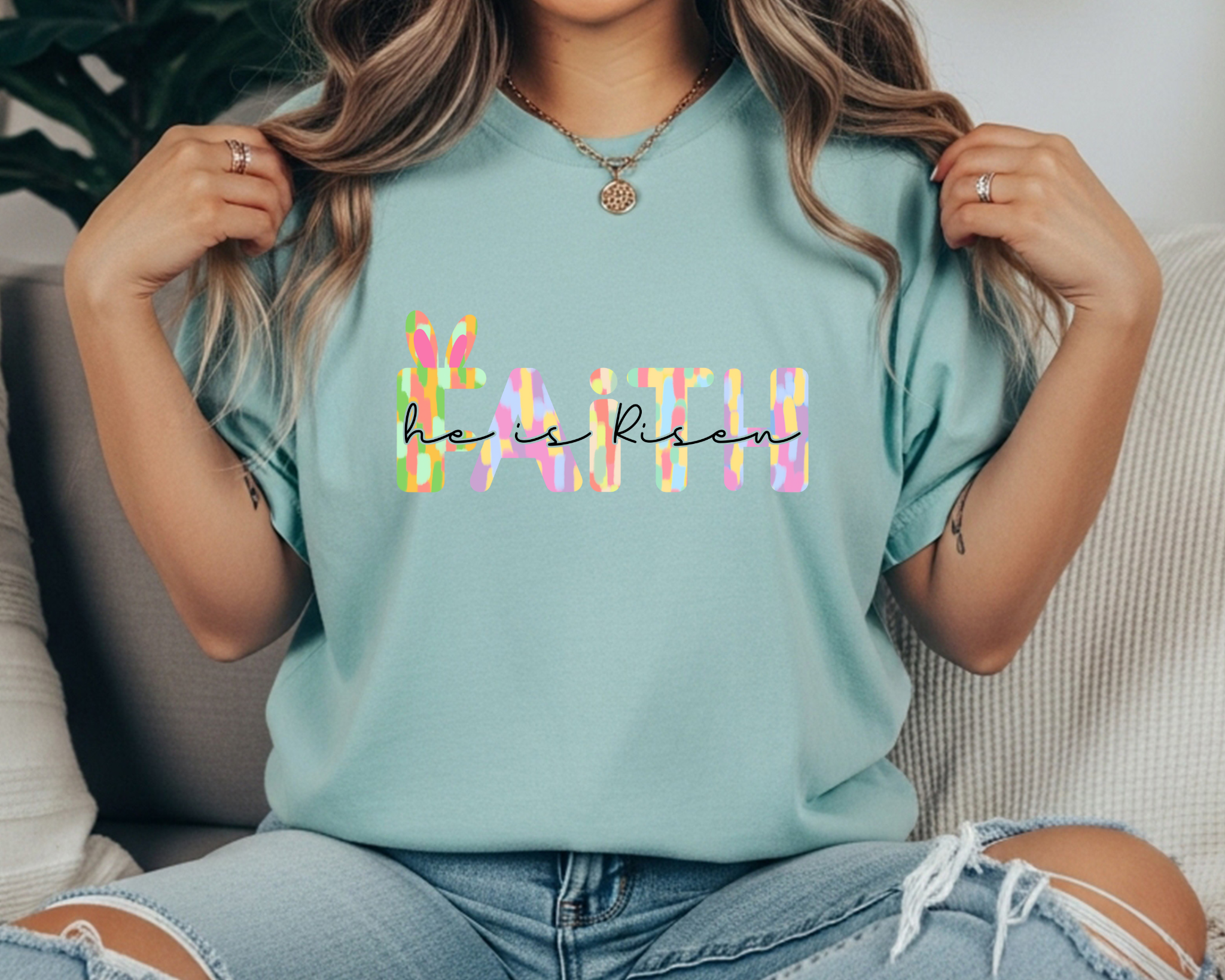 pastel “FAITH” text and black script reading “he is risen,” featuring a small bunny-and-cross detail for an Easter Christian graphic.
