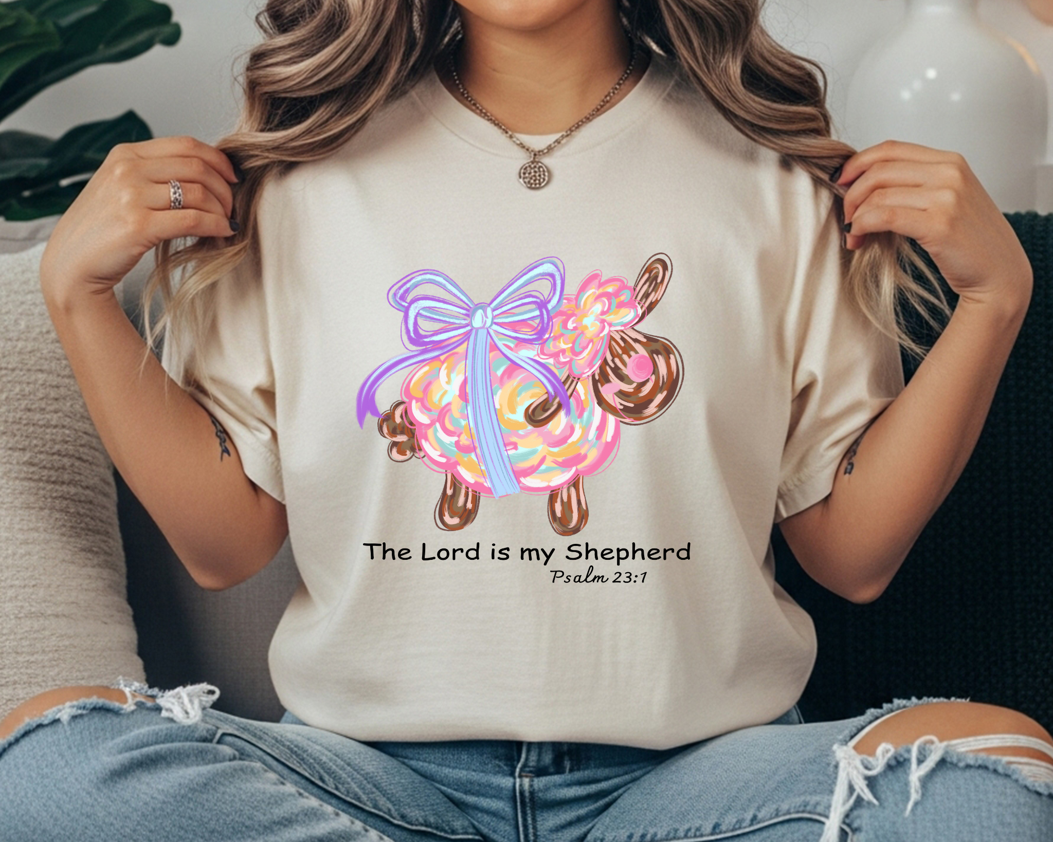 t-shirt with a colorful lamb graphic wearing a lavender bow and the phrase “The Lord is my Shepherd” with Psalm 23:1.