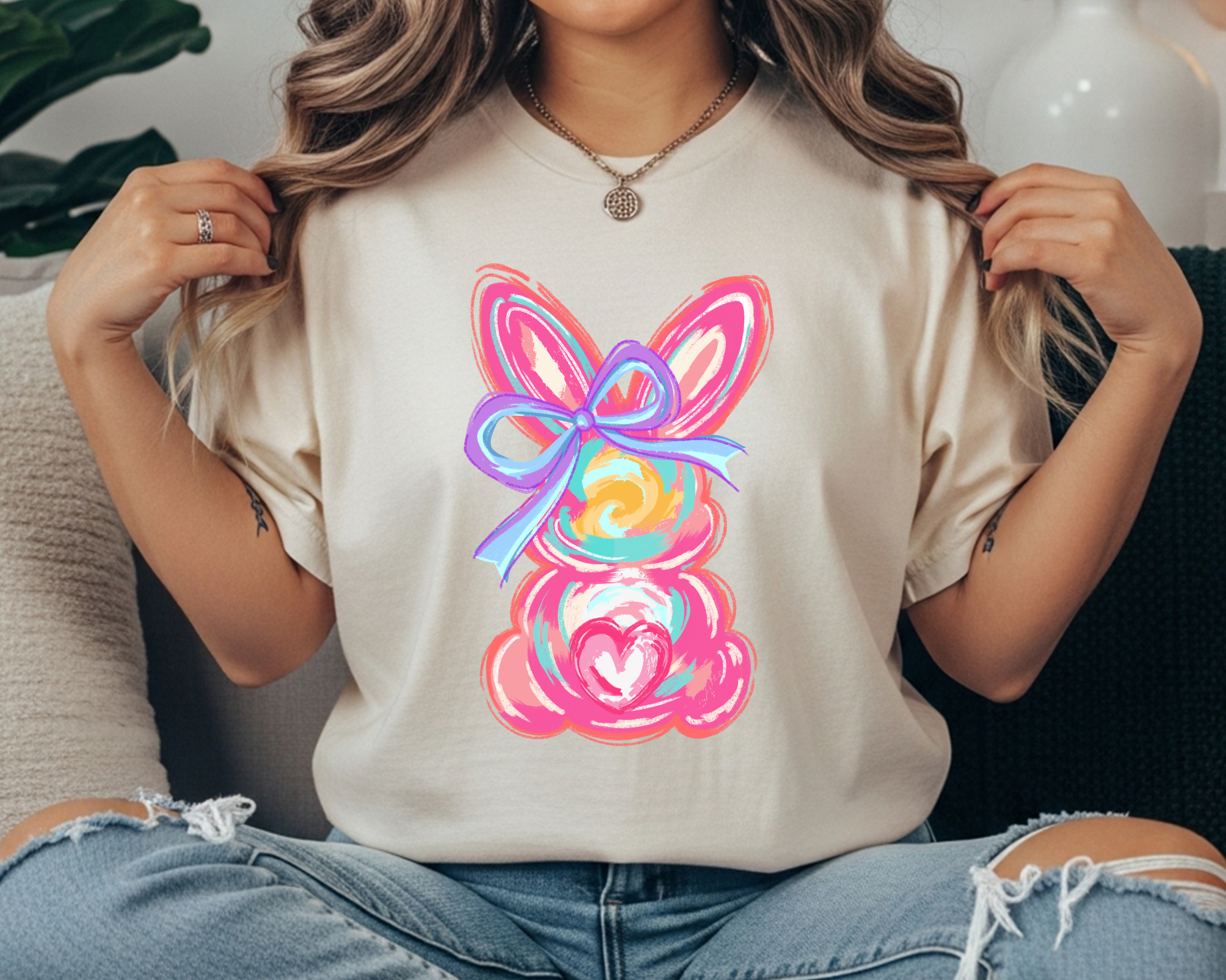 comfort colors t-shirt with a pastel painted bunny graphic featuring pink ears, a purple bow, and a heart detail.