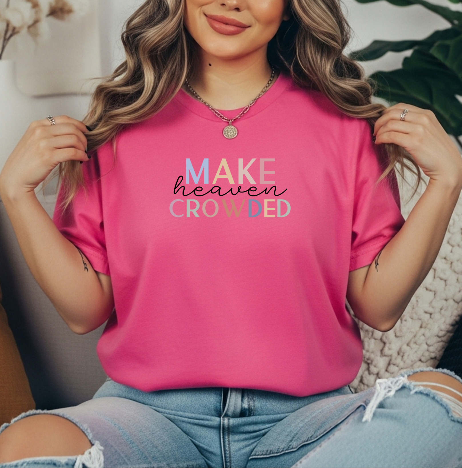 Woman wearing a bright pink Make Heaven Crowded Comfort Colors Christian tee, styled casually with jeans and layered necklaces.