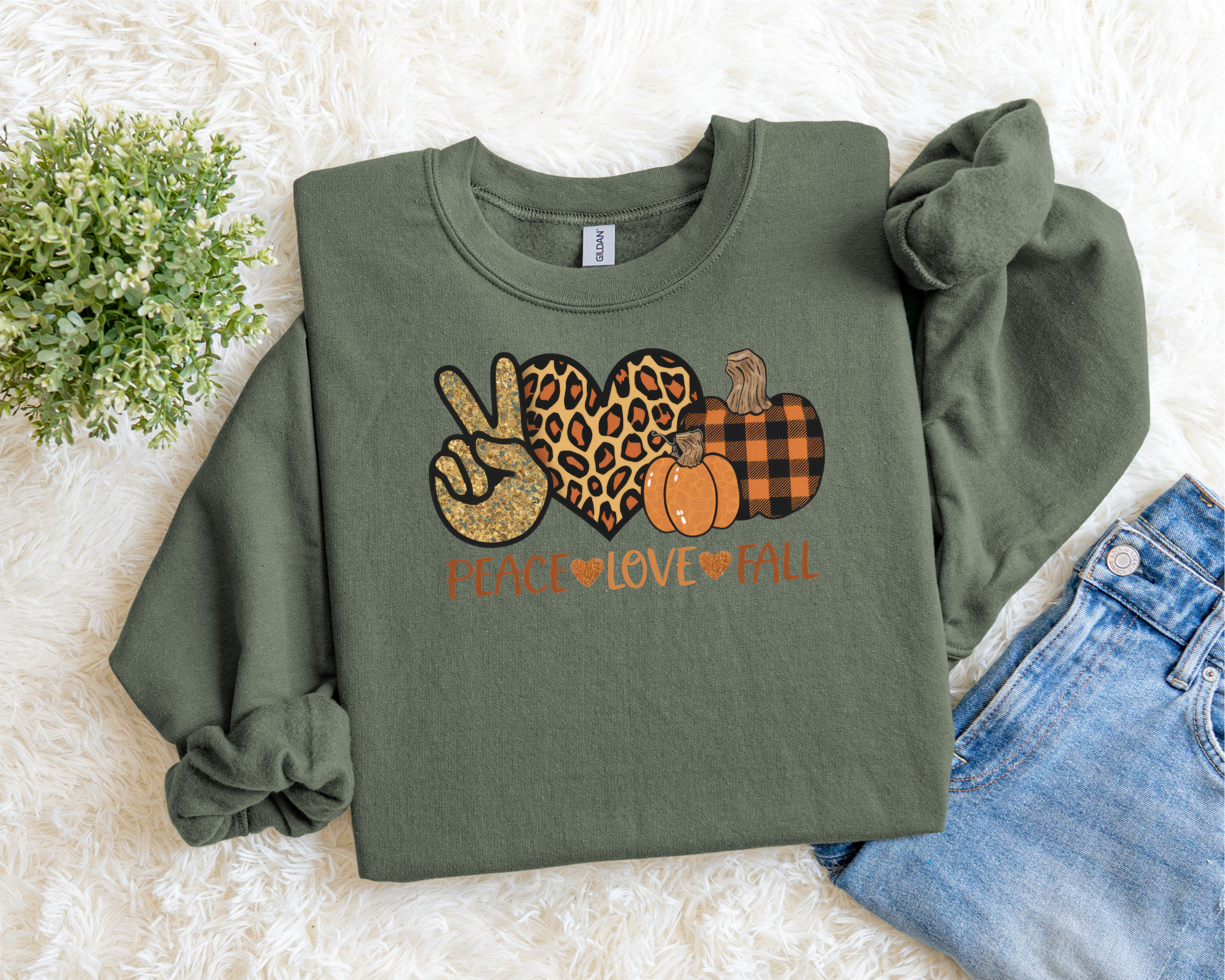 Green sweatshirt with autumn-themed design on a light background