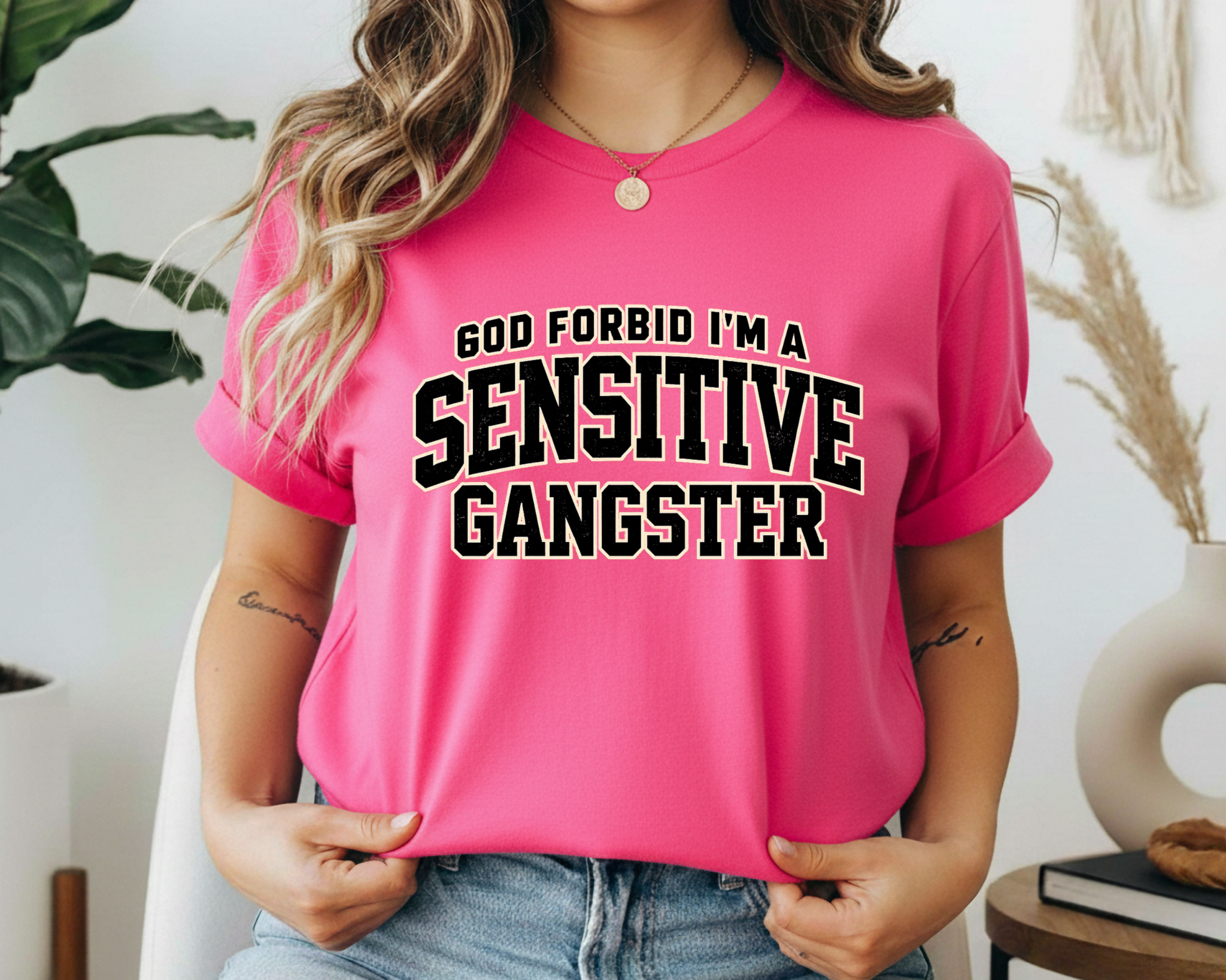 Person wearing a pink t-shirt with 'GOD FORBID I'M A SENSITIVE GANGSTER' text.