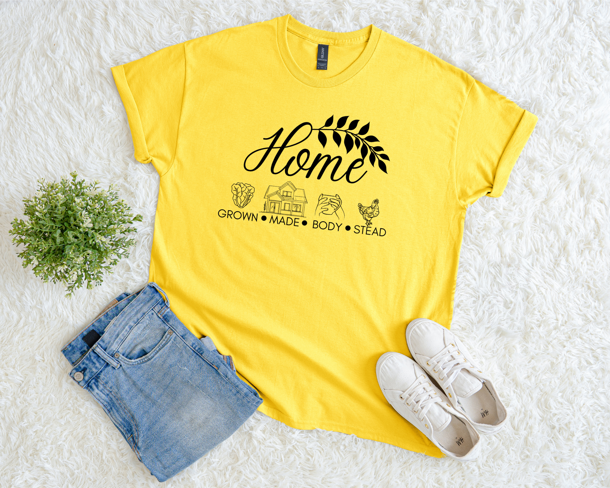 Yellow t-shirt with 'Home' graphic design on a white surface with denim shorts and white sneakers.