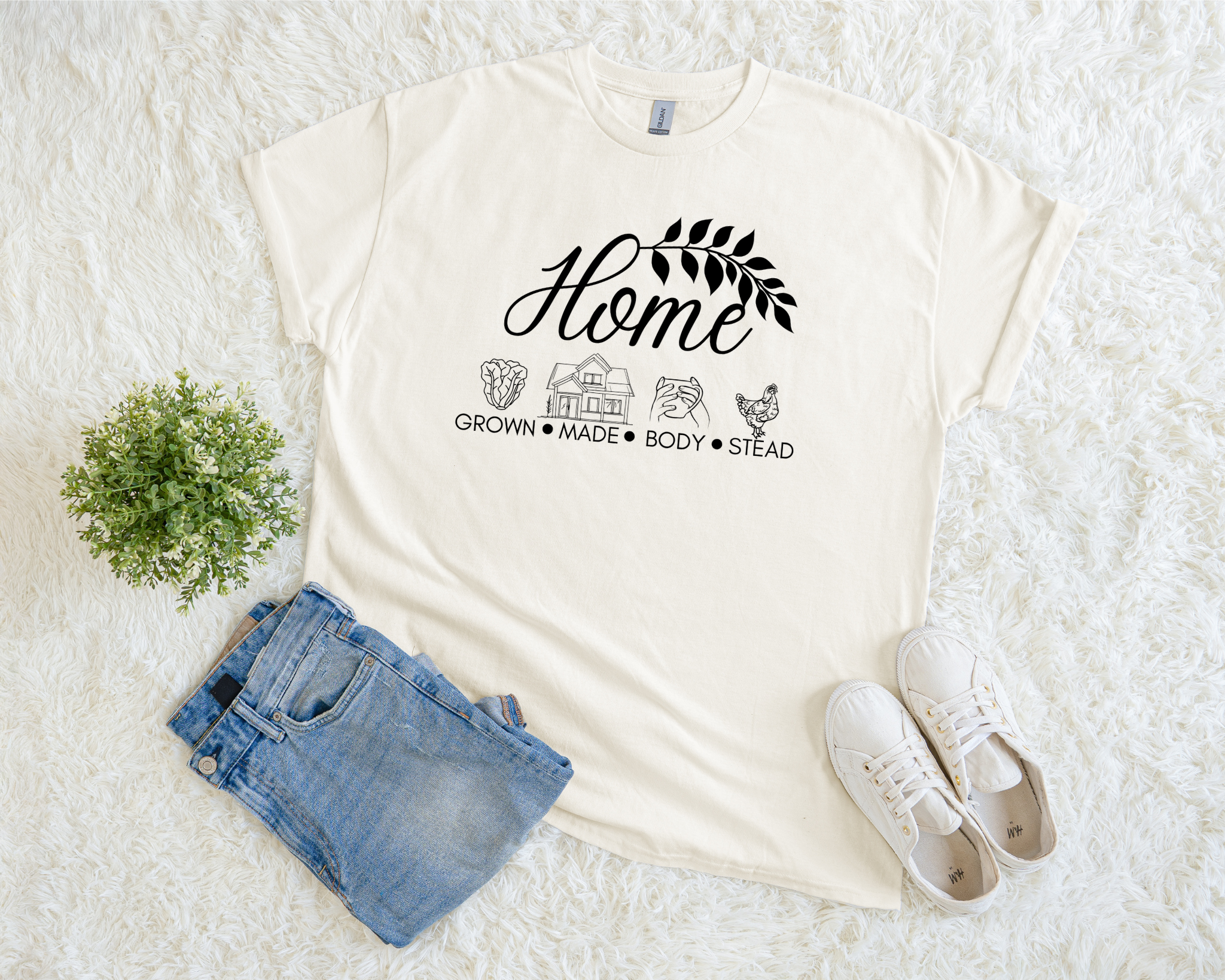 White t-shirt with 'Home' graphic design on a white surface with jeans and sneakers.
