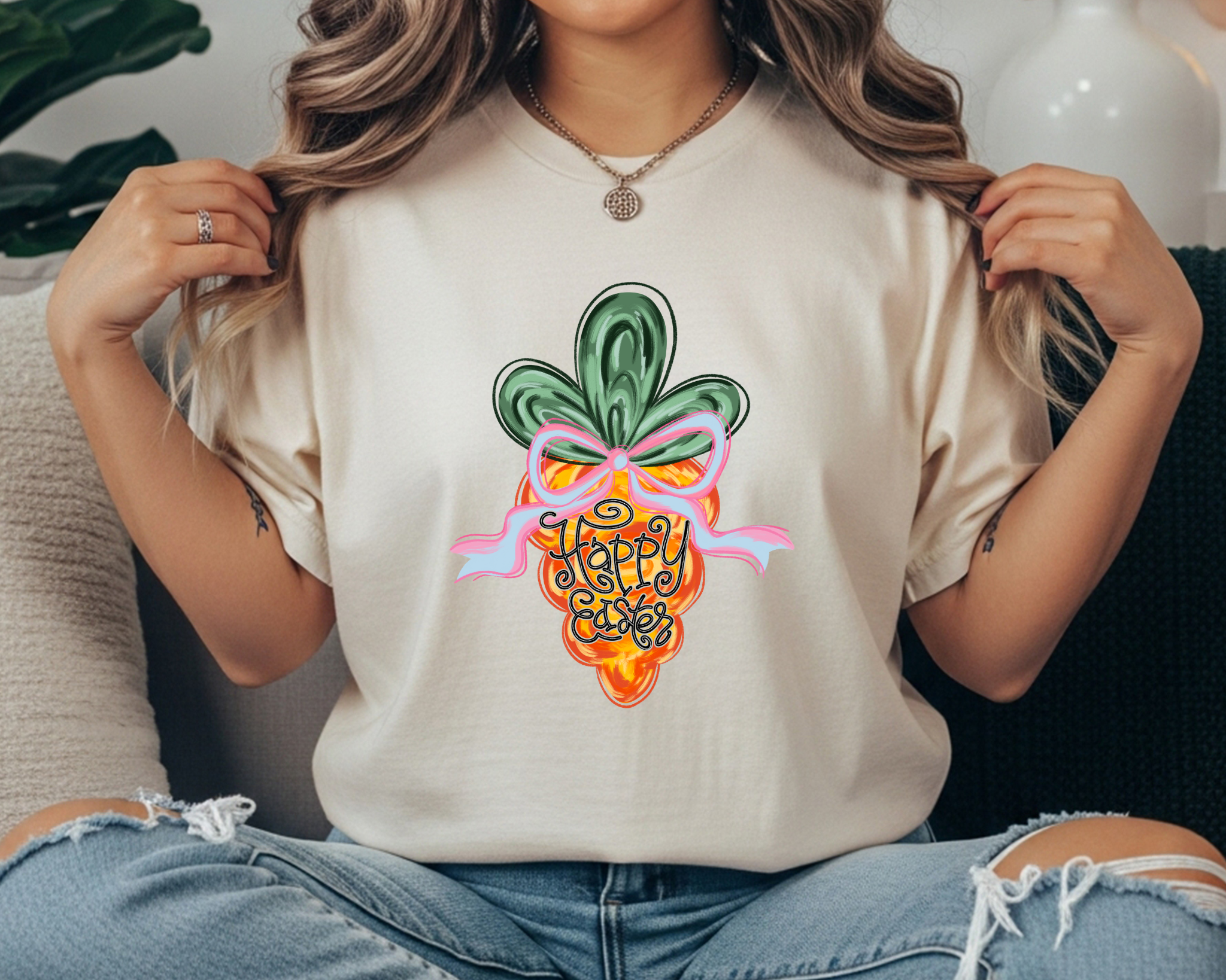 Comfort Colors t-shirt featuring a colorful carrot graphic with a pink bow and hand-lettered “Happy Easter” text in the center.