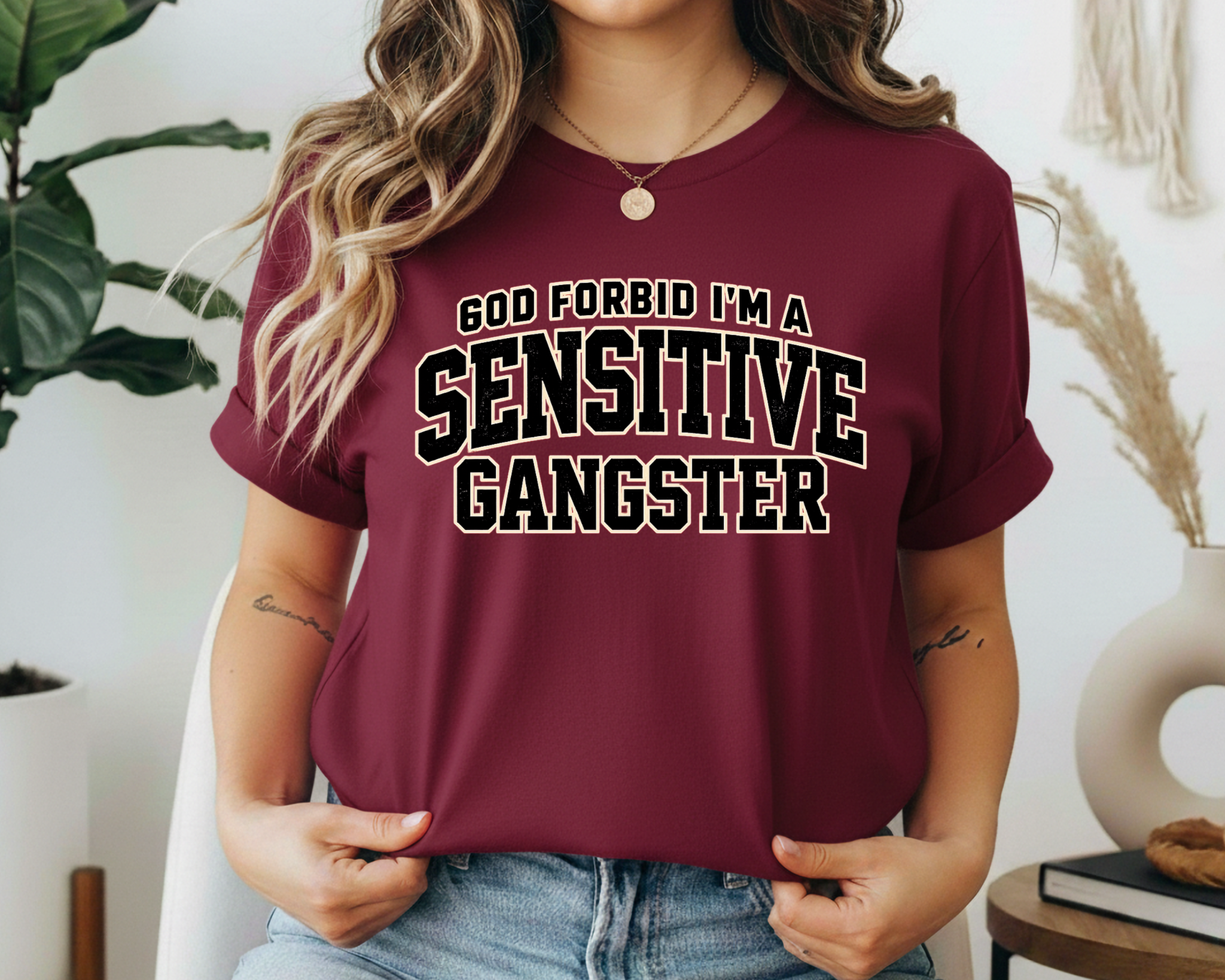 Person wearing a maroon t-shirt with text in a casual setting