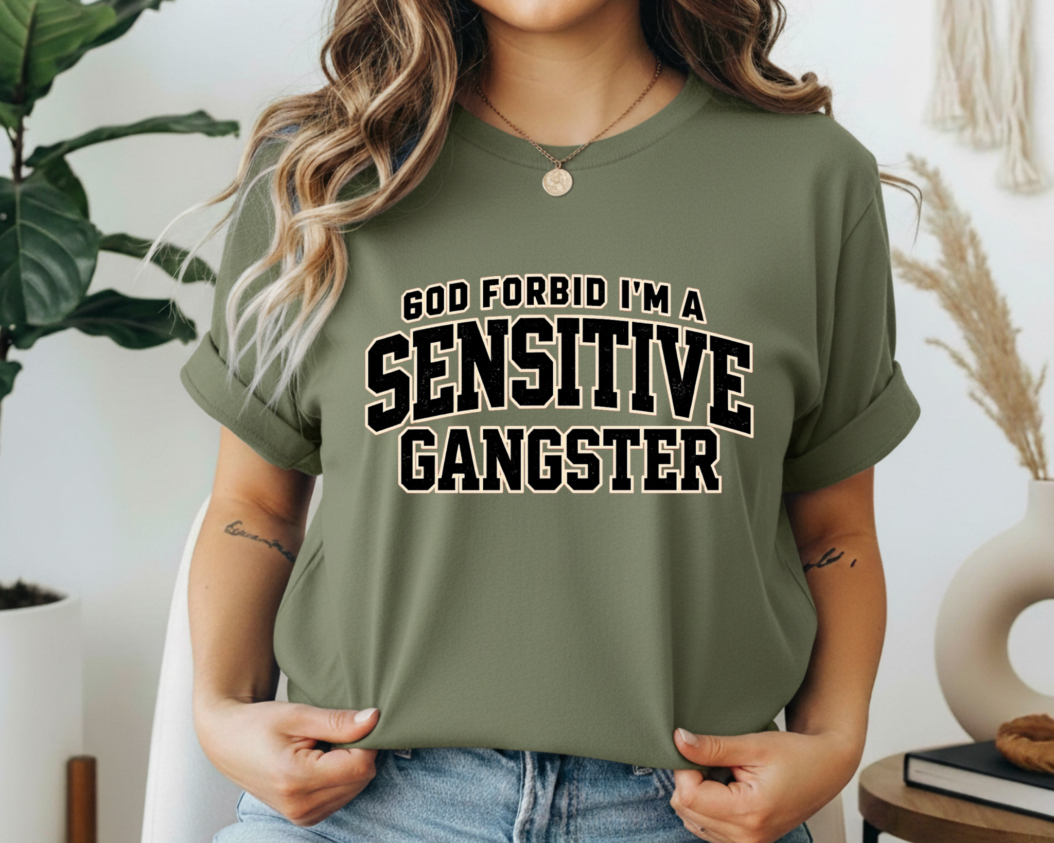 Person wearing a green t-shirt with 'Sensitive Gangster' text in a casual setting