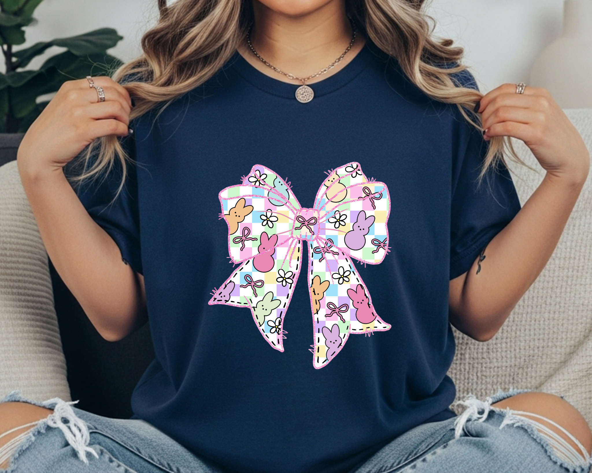 Comfort Colors t-shirt featuring a large pastel Easter bow graphic with bunny silhouettes, floral doodles, and a plaid pattern.