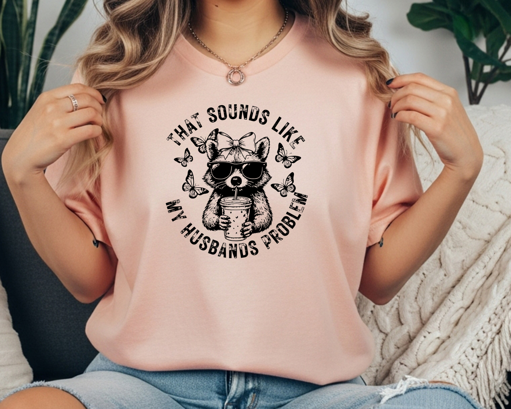 Comfort Colors t-shirt featuring a funny raccoon graphic with sunglasses, bow, iced coffee, and the phrase “That Sounds Like My Husband’s Problem.