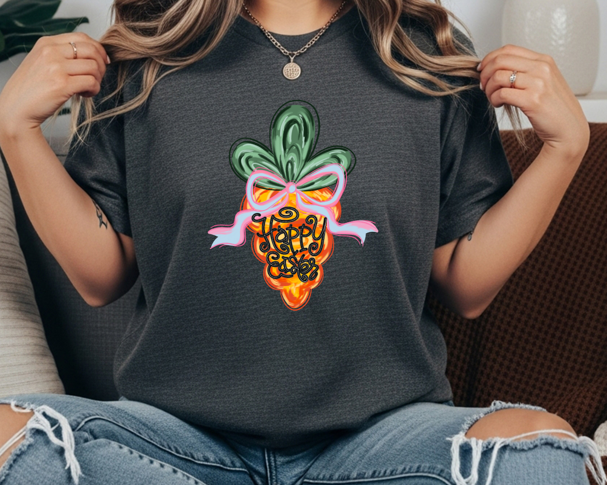 Comfort Colors t-shirt featuring a colorful carrot graphic with a pink bow and hand-lettered “Happy Easter” text in the center.