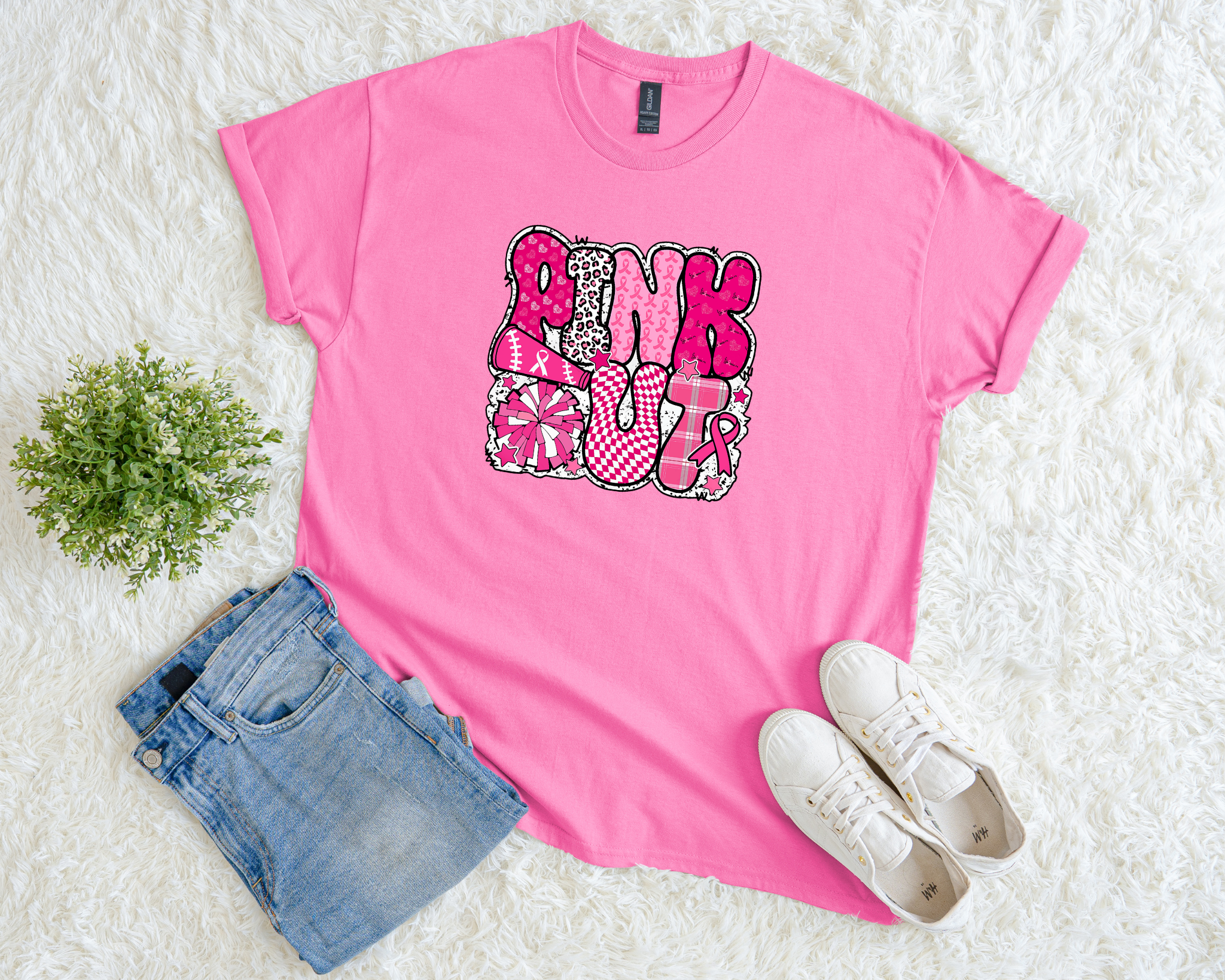  pink breast cancer awareness t-shirt with bold patterned lettering that reads “Pink Out” featuring cheer, sports, and pink ribbon designs.