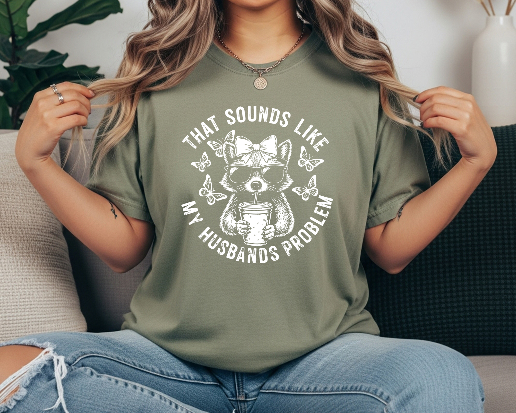 Comfort Colors t-shirt featuring a funny raccoon graphic with sunglasses, bow, iced coffee, and the phrase “That Sounds Like My Husband’s Problem.