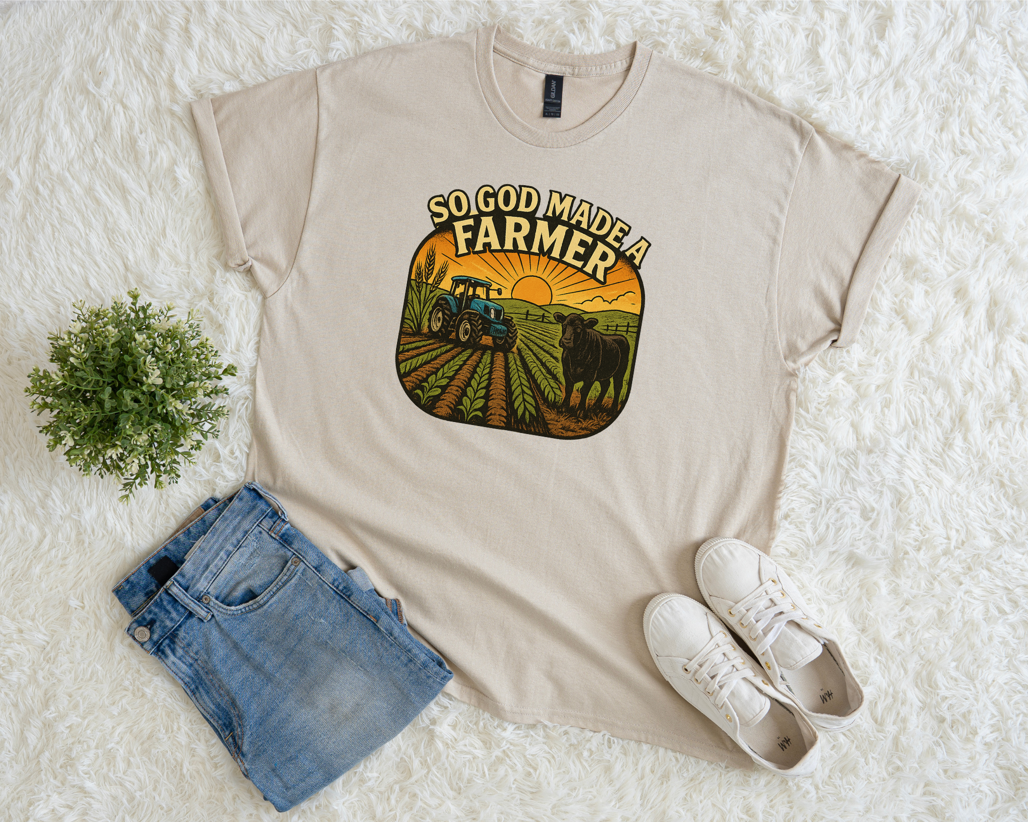 Beige t-shirt with 'So God Made a Farmer' graphic on a white surface with shorts and sneakers.