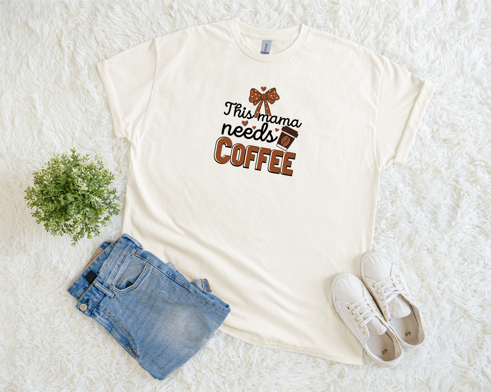 White t-shirt with 'This mama needs coffee' text, denim shorts, and white sneakers on a light background