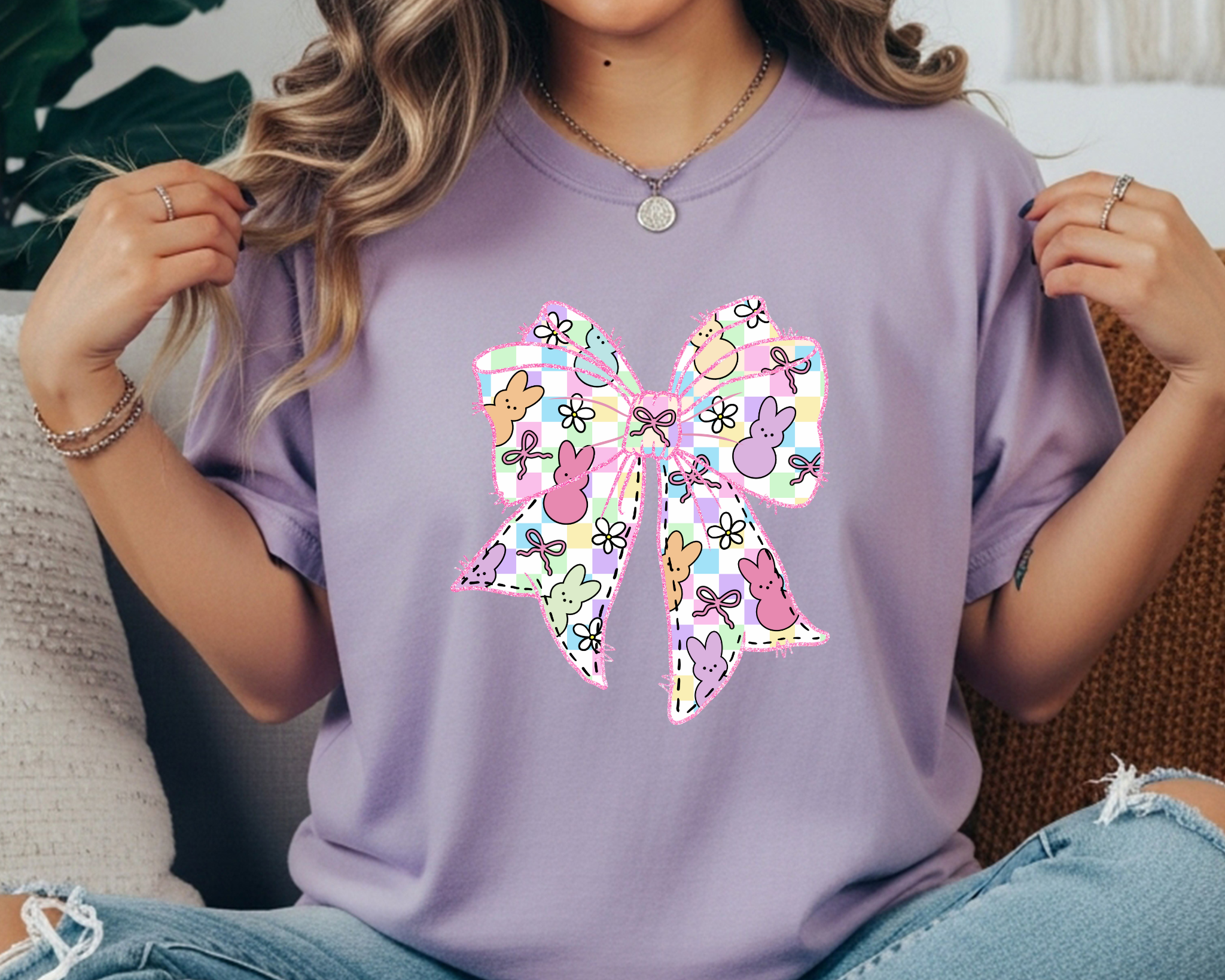 Comfort Colors t-shirt featuring a large pastel Easter bow graphic with bunny silhouettes, floral doodles, and a plaid pattern.