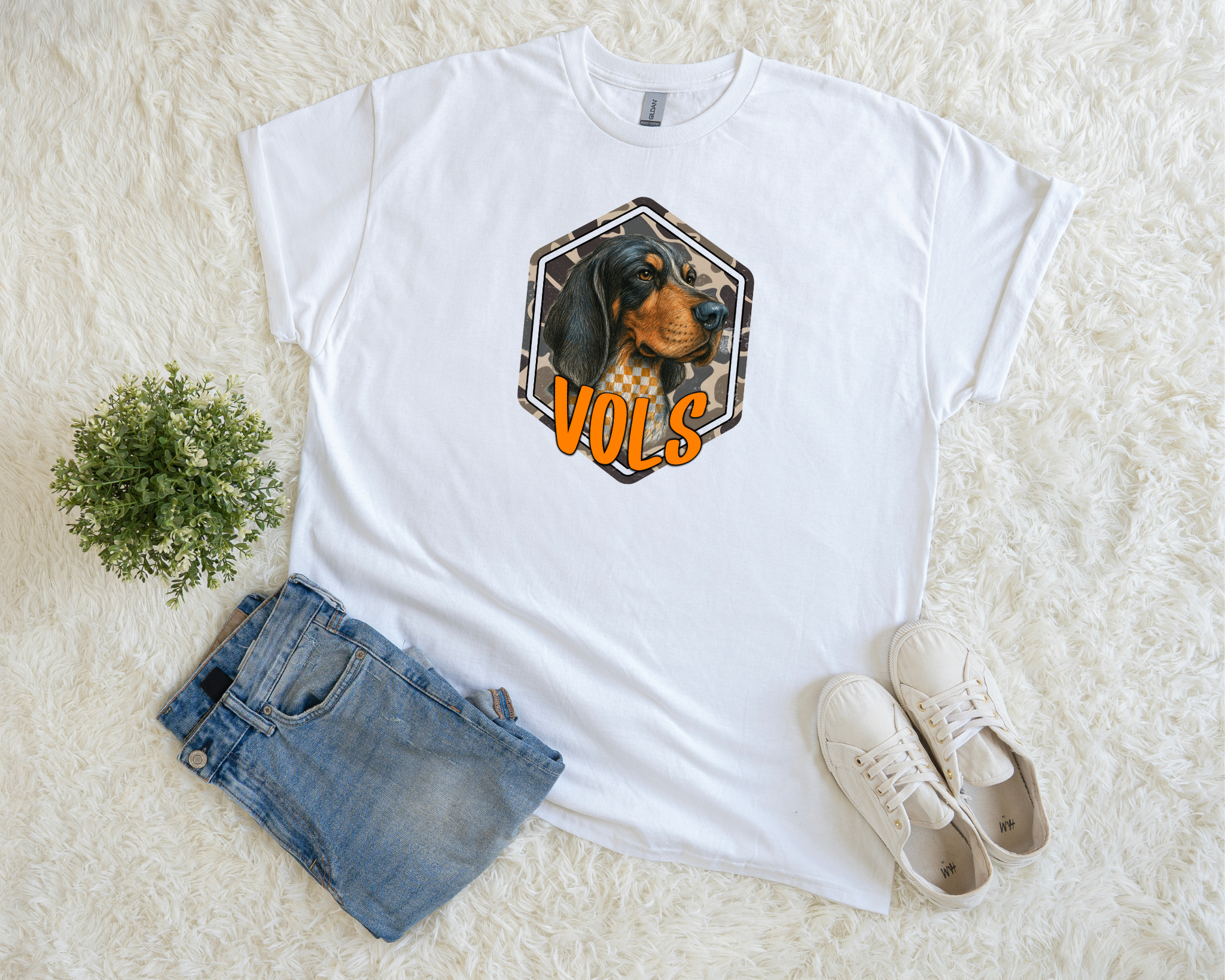 Adult camo Smokey VOLS t-shirt featuring a hound dog with checkerboard and camo accents, paired with bright orange “VOLS” text. A stylish, soft game-day tee for Tennessee fans.