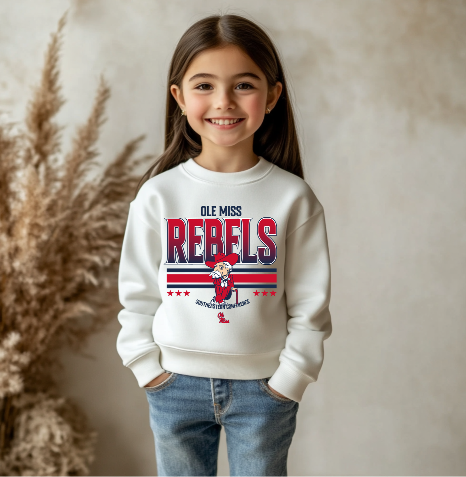 A youth-sized Ole Miss Rebels-inspired crewneck sweatshirt featuring bold red and navy graphics with a vintage-style mascot design, perfect for young fans who love football and Southern style.
